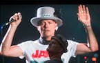 Lead singer Gord Downie is seen performing on a screen as a man watches during a viewing party for the final stop in Kingston, Ontario, from Vancouver