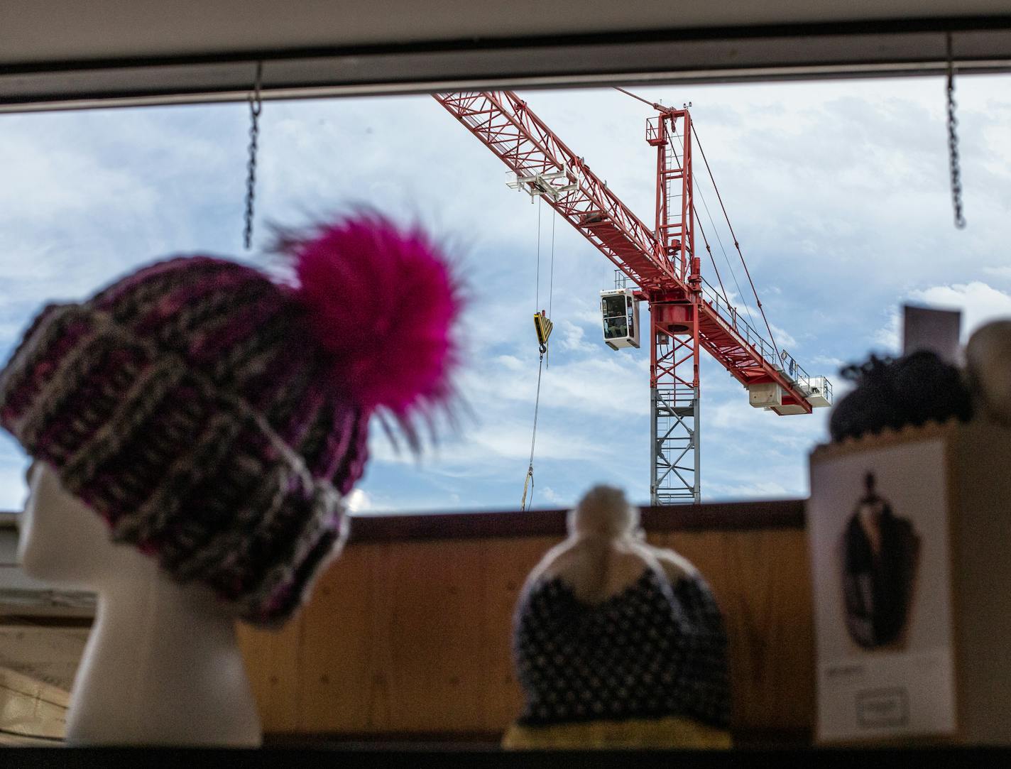 A crane can be seen through the window of Harriet and Alice, a small knitting and yarn boutique. The shop is very close to the construction site. ] ALEX KORMANN &#x2022; alex.kormann@startribune.com The simultaneous construction of the Nolan Mains luxury apartment and some parking ramps just south of 50th & France has negatively affected several businesses in the district. Large cranes loom over the small shops and restaurants as few pedestrians walk the streets. Some stores have embraced a sens