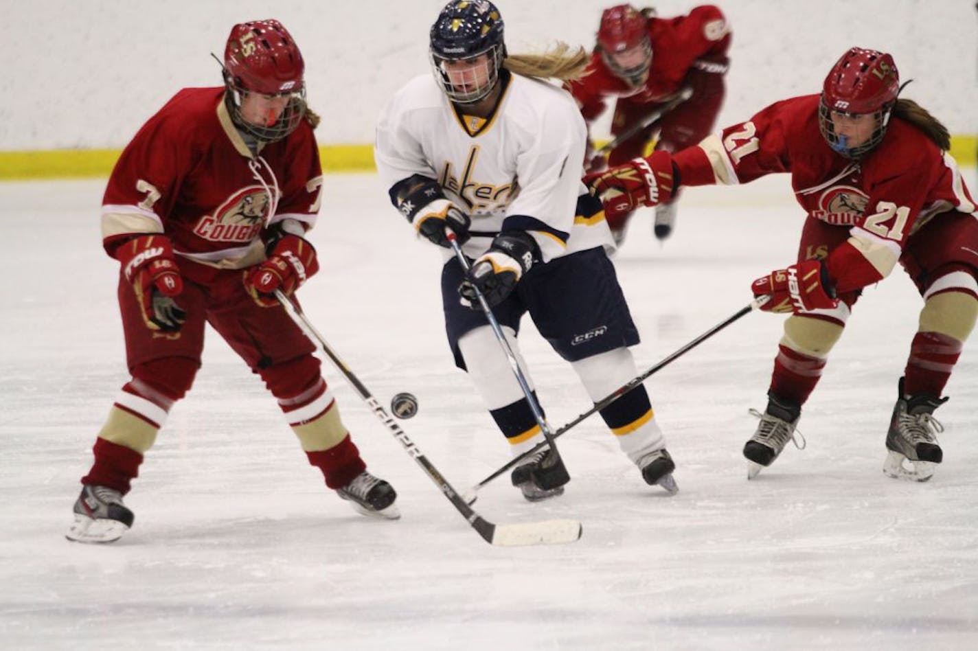 Lakeville South forwards Megan Morse (7) and Jordan Gill (21) challenged Prior Lake forward Brittney Schulz for the puck in a recent game. The Cougars (19-5-1), under first-year coach and former Olympian Natalie Darwitz, are the second seed behind rival Lakeville North in Class 2A, Section 1.