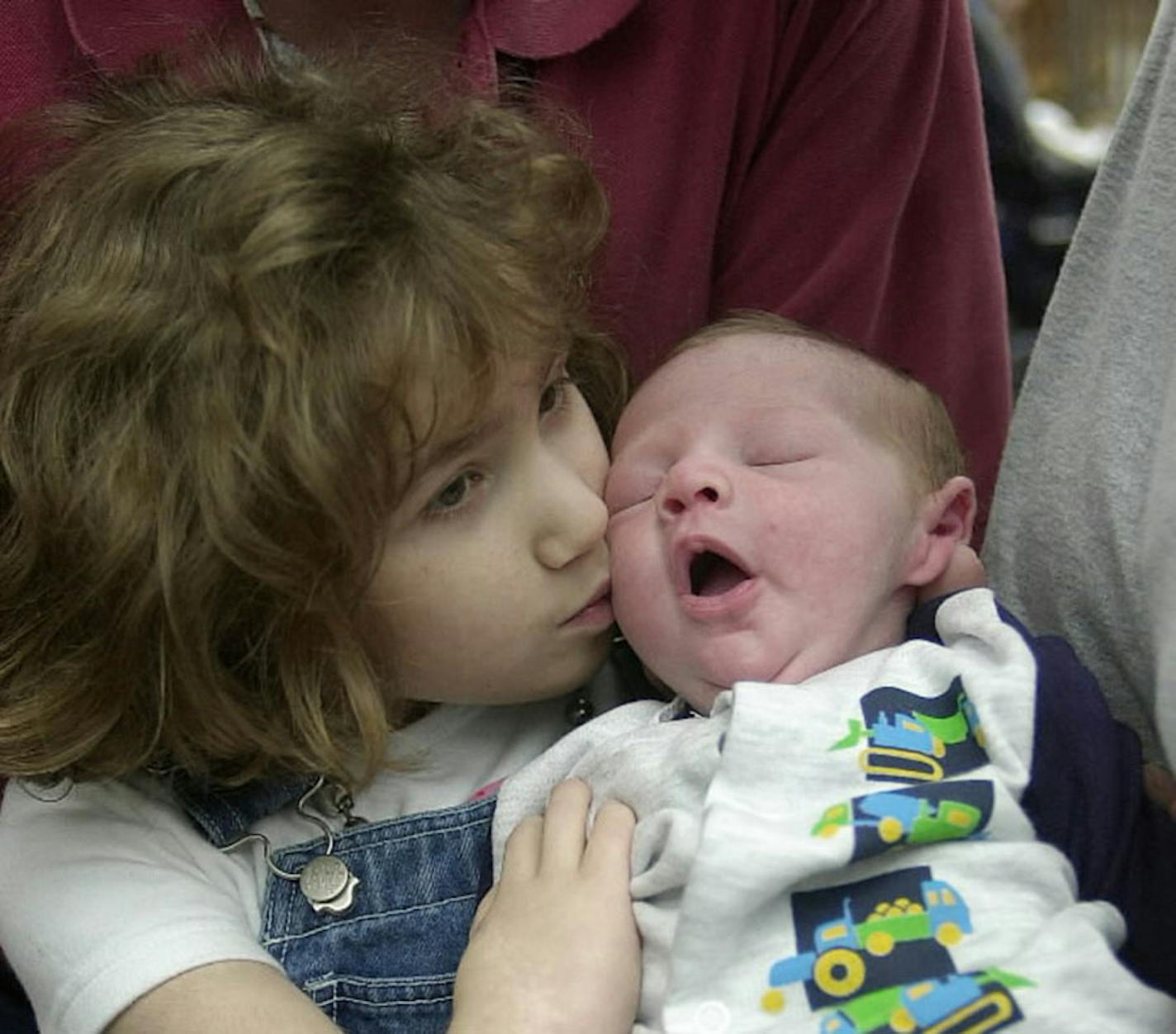 During a family portrait in 2000, Molly Nash gives her 4-week-old brother, Adam, a kiss. Molly Nash received some umbilical blood from her brother, saving her from a fatal genetic disease.