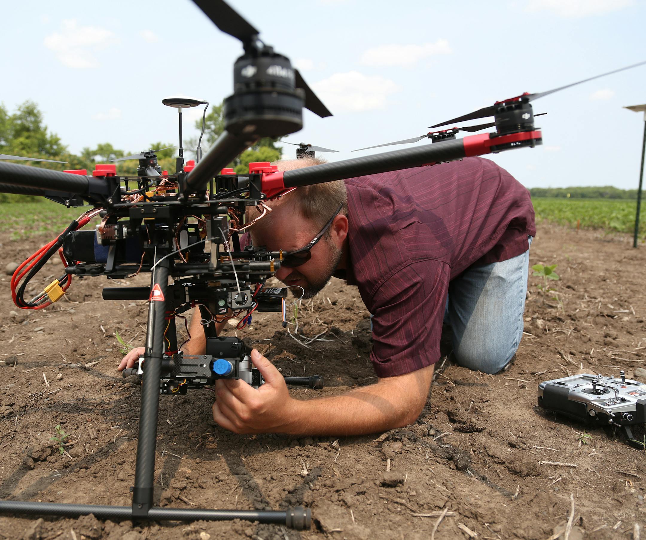 Tim Baker, senior field technician of at Northwest research and outreach center, position the camera on their drone before one of the test flights. ] (KYNDELL HARKNESS/STAR TRIBUNE) kyndell.harkness@startribune.com University of Minnesota researchers are testing how well drones, or unmanned aircraft systems, detect insects like soybean aphids and potato beetles. in Rosemount, Min., Thursday, July 7, 2015.