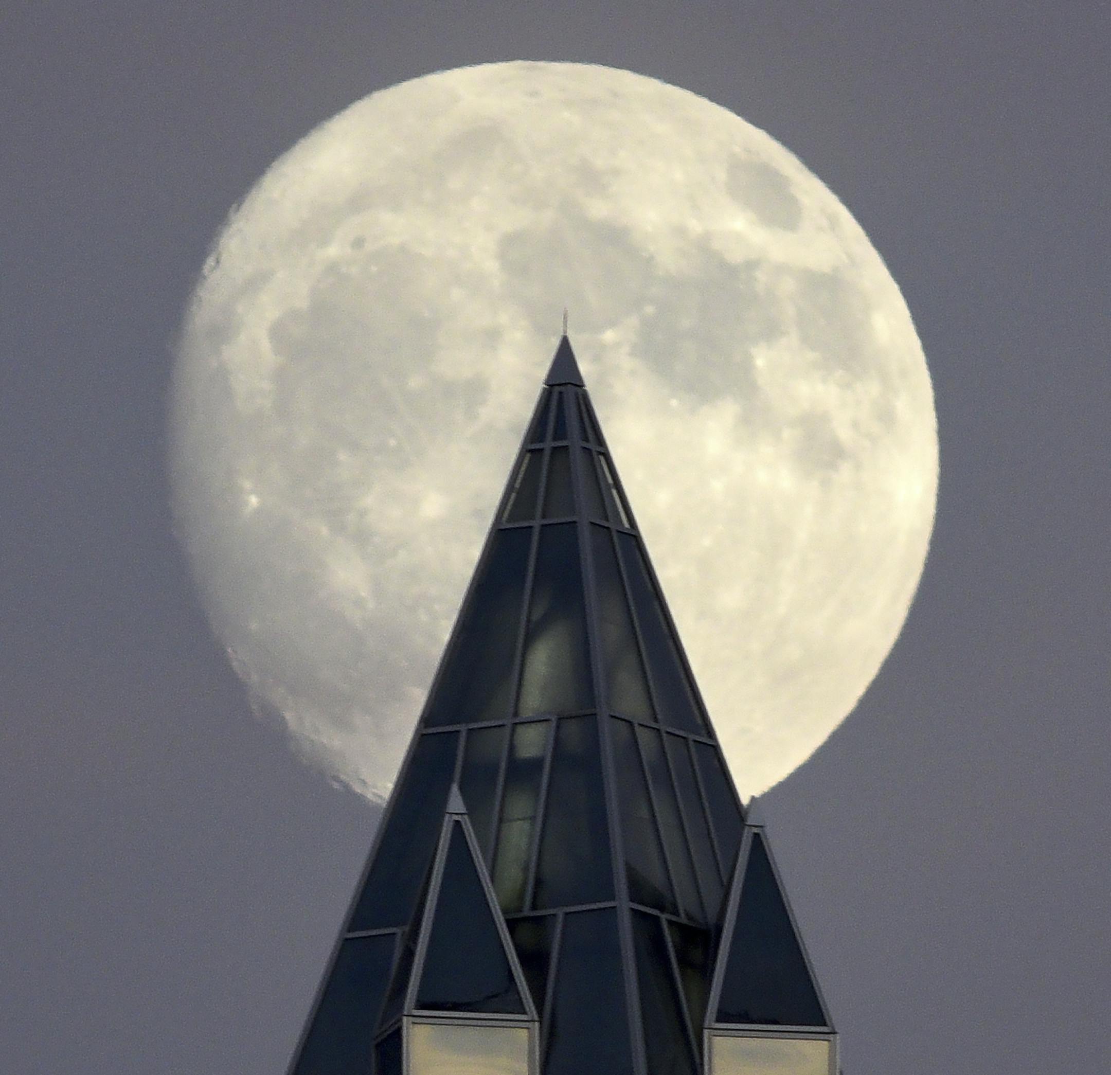 December's nearly full moon, known as the Cold Moon, rises over One PPG Place Downtown Pittsburgh, Friday, Dec. 1, 2017. It's a perigee moon, the closest the moon will be to earth this year. (Bob Donaldson/Pittsburgh Post-Gazette via AP)
