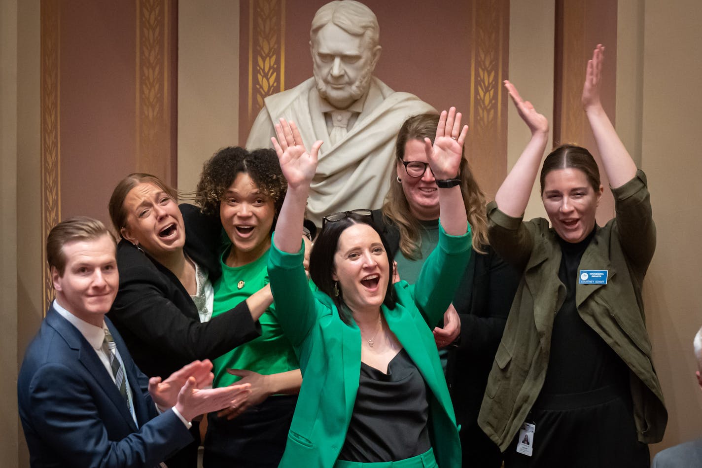 Sen. Lindsey Port, DFL-Burnsville, center, author of the marijuana bill, and other senators and staff members including Sen. Clare Oumou Verbeten, DFL-St. Paul and Sen. Grant Hauschild, DFL-Hermantown, left, after the votes were counted and the bill passed in the Senate Friday.