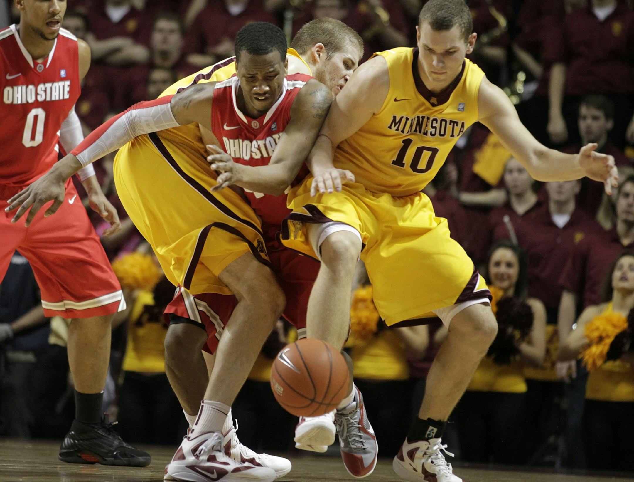 Ohio State's William Buford was sandwiched between Minnesota's Elliott Eliason and Oto Osenieks during Tuesday night's matchup between Ohio State and the University of Minnesota February 14, 2012 in Minneapolis, Minnesota.