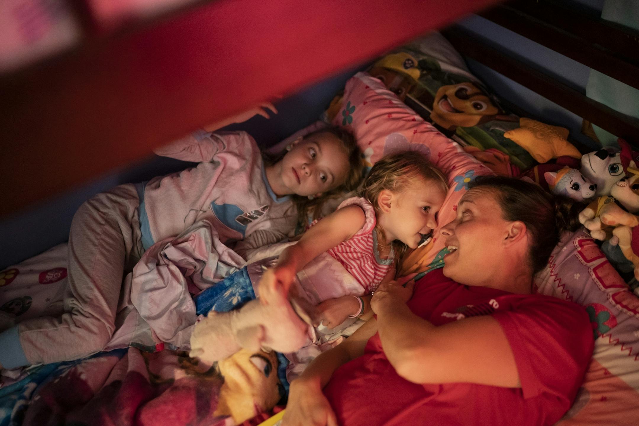 Jeanette Chafee snuggled and read a book with her daughters Madison, 8, and Ally, 3, at home in Scandia, Minn., on Wednesday, September 18, 2019. Bedtime will be one of the biggest adjustments for her girls while she deploys since she puts them to bed most nights.