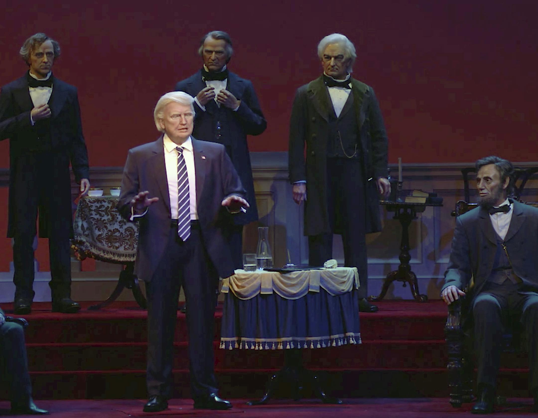 This undated video screen shot provided by Walt Disney World shows an animatronic figure of Donald Trump, center front, at the Hall of Presidents attraction at Walt Disney World in Orlando, Fla. The Trump figure moves his head during the traditional roll call of leaders, motions with his arms and gives a brief speech. (Walt Disney World via AP)