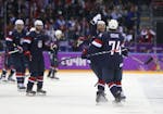 U.S. forward T.J. Oshie (74), right, celebrates with teammates after he scored the winning goal in a shootout with Russia during a men's preliminary-r