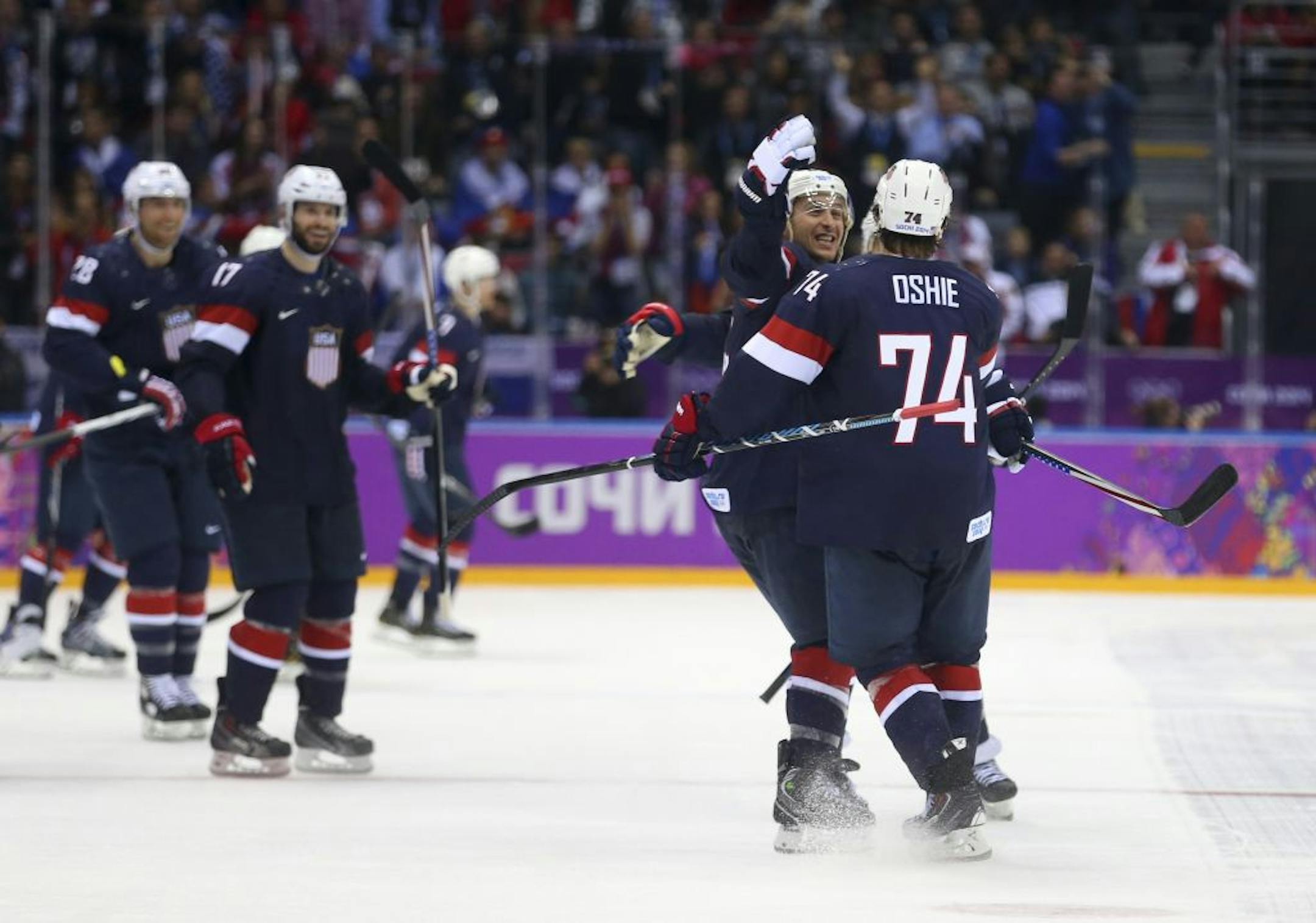 U.S. forward T.J. Oshie (74), right, celebrates with teammates after he scored the winning goal in a shootout with Russia during a men's preliminary-round hockey game inside Bolshoy Ice Dome at the 2014 Winter Olympics in Sochi, Russia, Feb. 15, 2014. The U.S. won 3-2.
