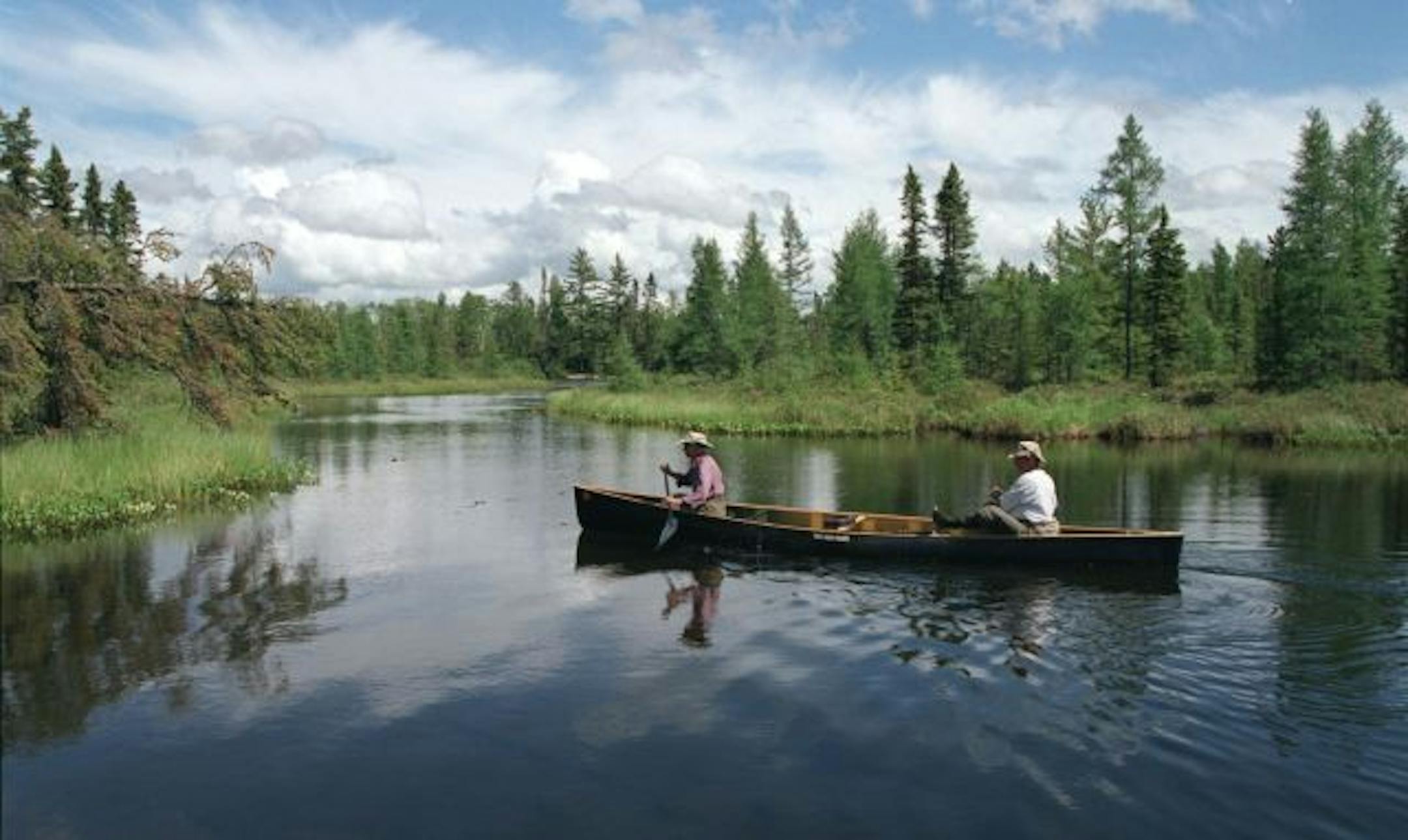MNMIT101-BWCAW, MN June 14-15 2000, Bert and Diane Heep, a couple from Ely, MN. in thier 50�s spend the summer canoing the Boundary Waters Canoe Area Wilderness and Quetico park ( Canada). -- TThis picture... Diane and Bert Heep glide toward a shallow portage during a day trip from their campsite on Thomas lake to Insula Lake, the morning rain showers finally parted for a glimpse at blue sky before the evening rain moved in. they are paddling a lightweight ( 41 lbs) kevlar canoe. STAR TRIBUNE PH