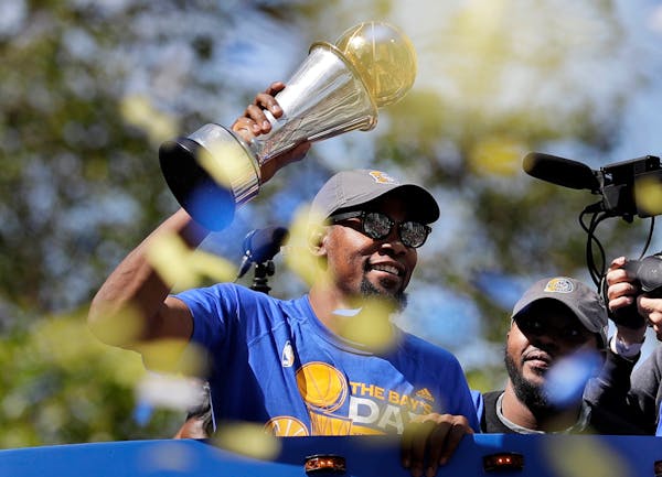 The Warriors' Kevin Durant held the NBA Finals MVP trophy during a parade and rally celebrating the Warriors' NBA championship in Oakland, Calif., in 