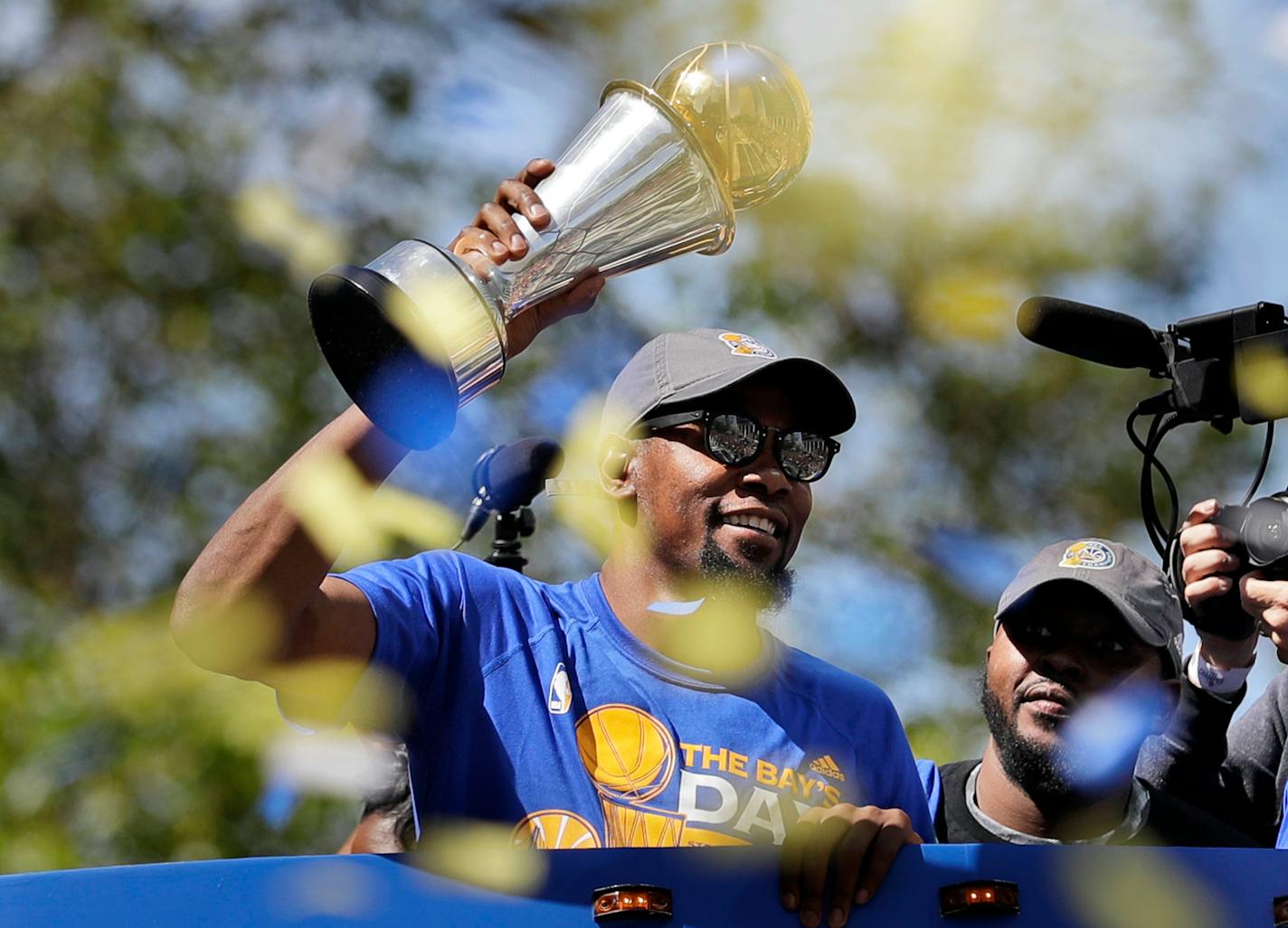 The Warriors' Kevin Durant held the NBA Finals MVP trophy during a parade and rally celebrating the Warriors' NBA championship in Oakland, Calif., in June.