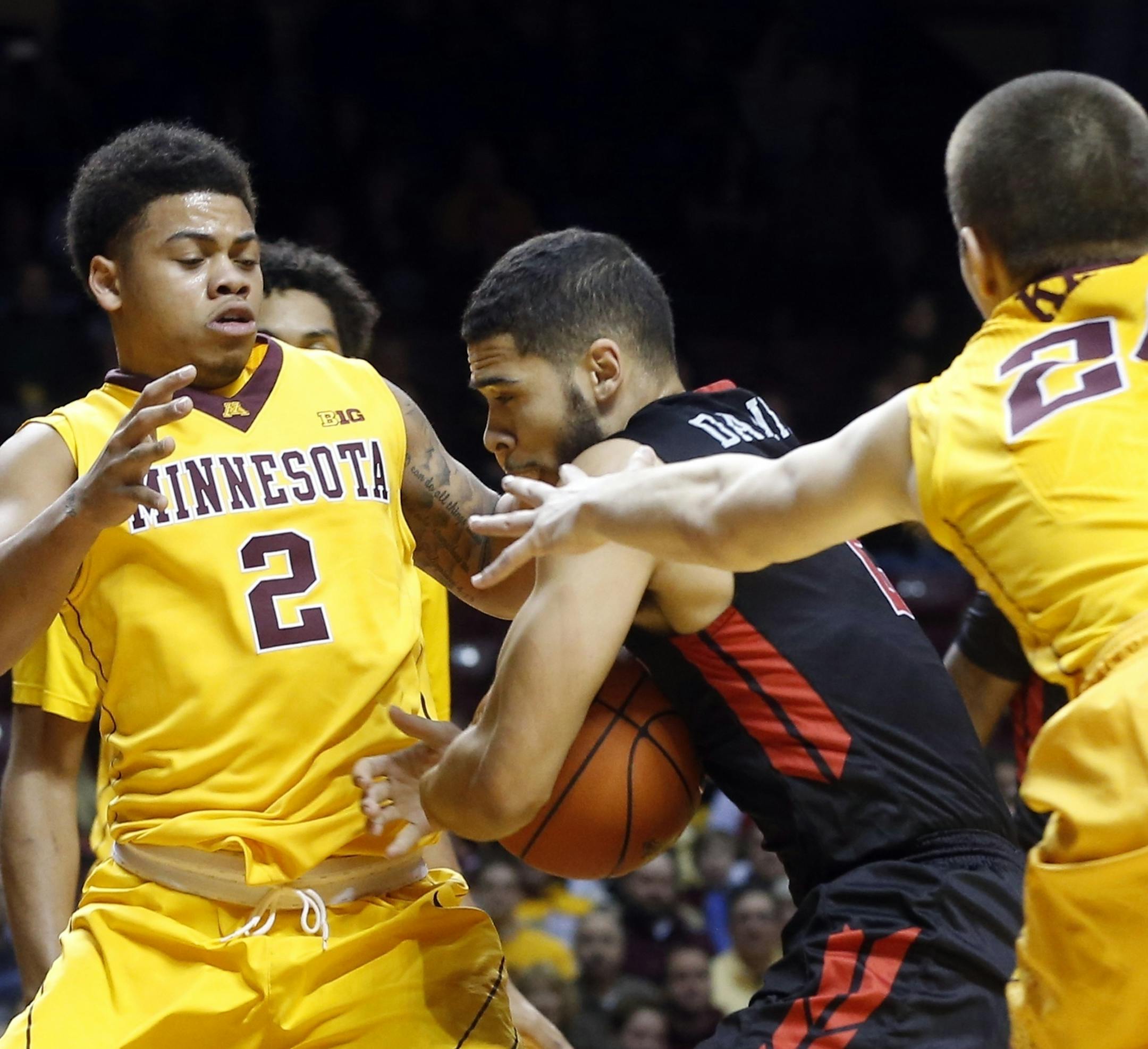 Rutgers' Bishop Daniels, center, tries to squeeze between Minnesota's Nate Mason, left, and Joey King during the first half of an NCAA college basketball game Tuesday, Feb. 23, 2016, in Minneapolis. (AP Photo/Jim Mone)