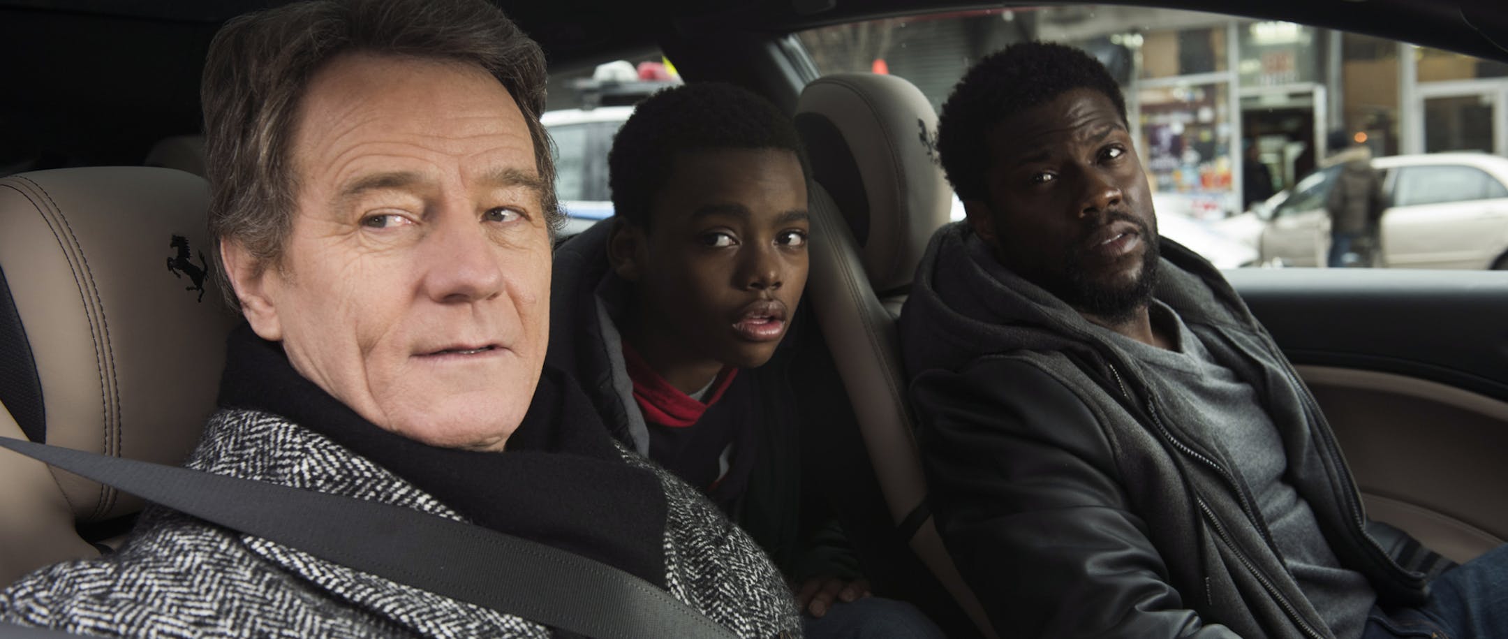 This image released by STXfilms shows Bryan Cranston, from left, Jahi Di'Allo Winston, and Kevin Hart in a scene from "The Upside." (David Lee/STXfilms via AP)