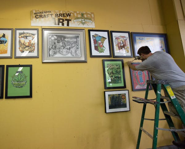 Travis Anderson hung Minnesota brewery art Monday at the Land of 10,000 Beers exhibit in the State Fair&#x2019;s Agriculture/Horticulture building.