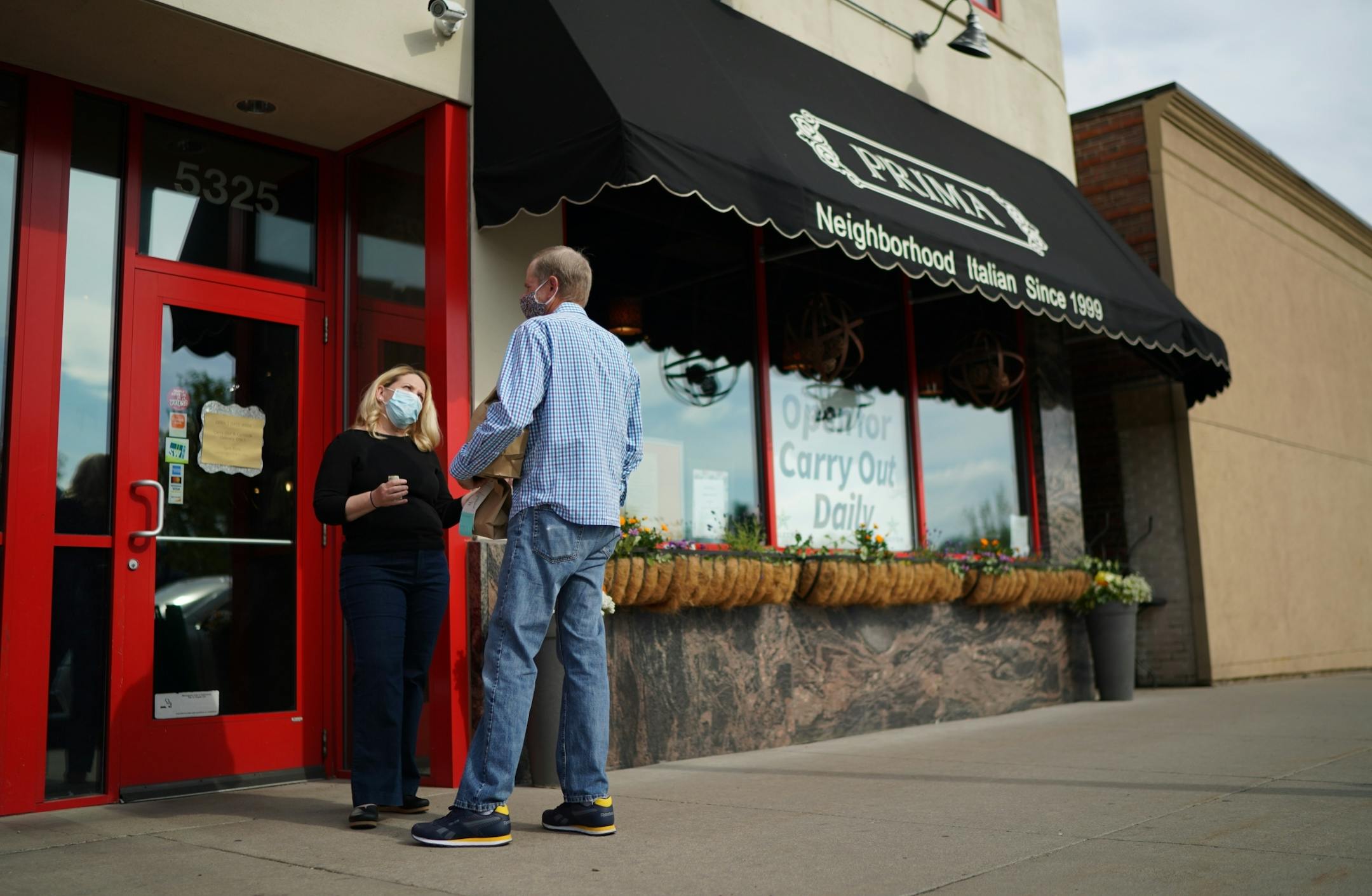 Jennifer King, owner of Prima, talked to a long time customer who came by for a take out order. She kept an eye on the food delivery parking spots in front of her restaurant on Lyndale Ave and she delivered their orders. In between deliveries, she checked for incoming orders on her phone.