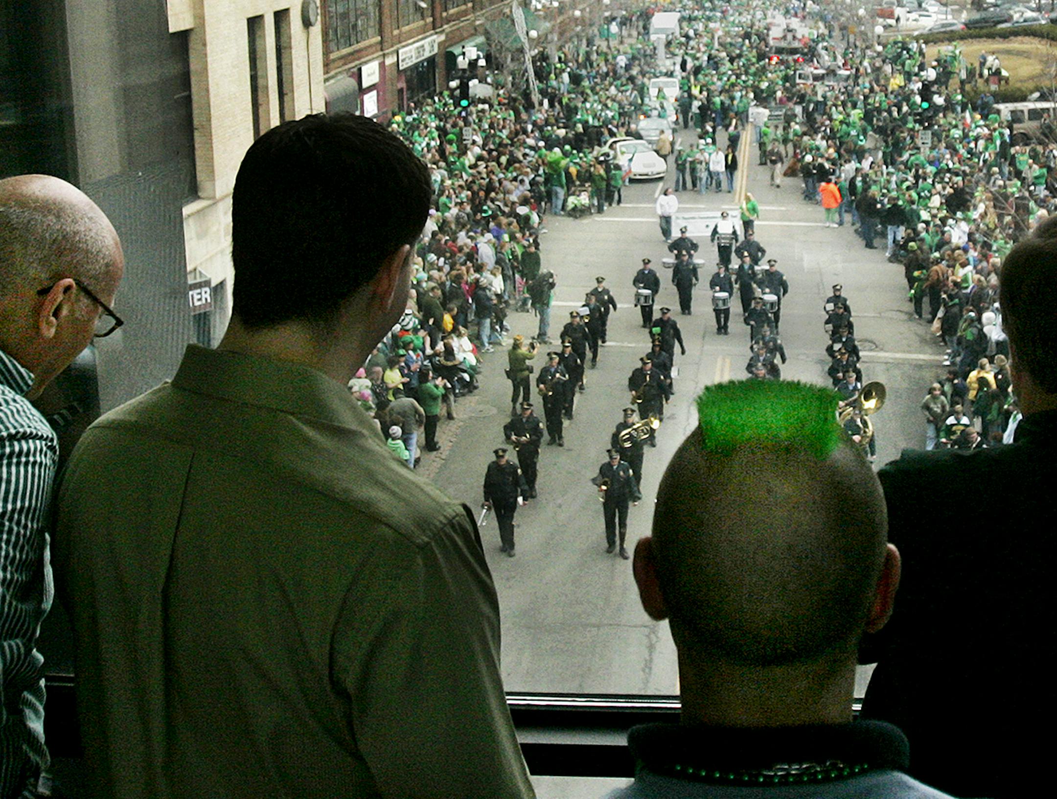 DAVID JOLES ‚Ä¢ djoles@startribune.com St. Paul, MN - Spectators, including a man with a green mohawk, watch from the TPTV skywa, St. Patrick's Day parade parade down below, along 4th Steet. Thousands filled the streets for the celebration. ORG XMIT: MIN2014031418051726