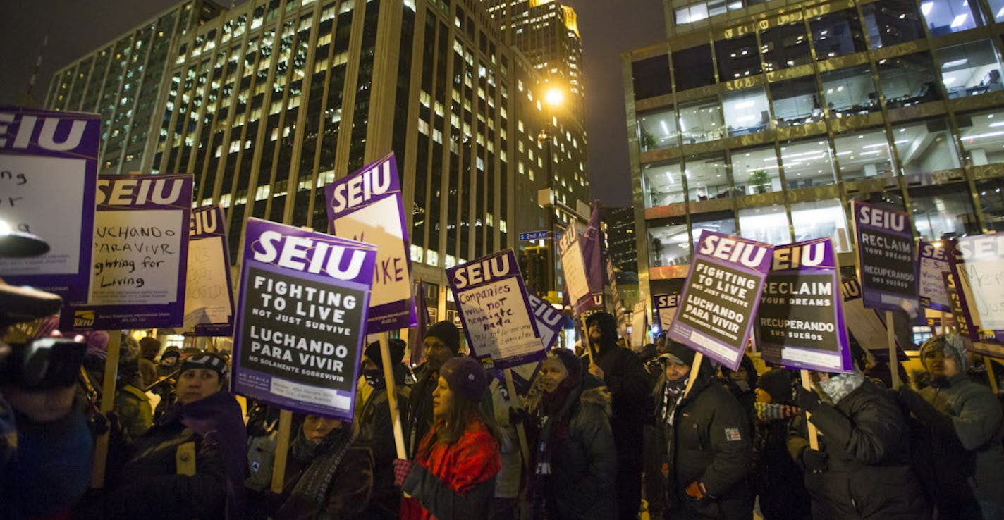 People walked holding signs in a circle during a one-day protest for local janitors a outside the U.S. Bank building on Wednesday, February 17, 2016, in Minneapolis, Minn. ] RENEE JONES SCHNEIDER &#x2022; reneejones@startribune.com