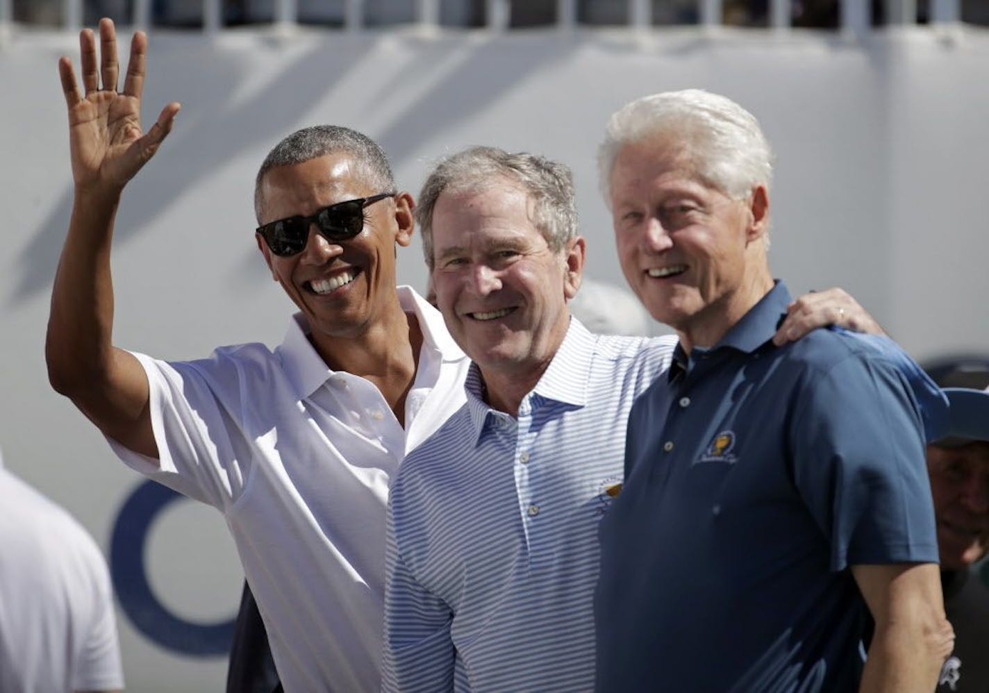 Former U.S. Presidents, from left, Barack Obama, George Bush and Bill Clinton greet spectators on the first tee before the first round of the Presidents Cup at Liberty National Golf Club in Jersey City, N.J., Thursday, Sept. 28, 2017.