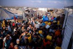 Palestinians displaced by the Israeli bombardment of the Gaza Strip queue for water at a makeshift tent camp in the southern town of Khan Younis, Mond