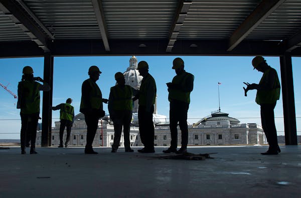 Members of the media and Mortenson Construction employees stand around the top floor of the new Senate Office Building during a tour on Tuesday aftern