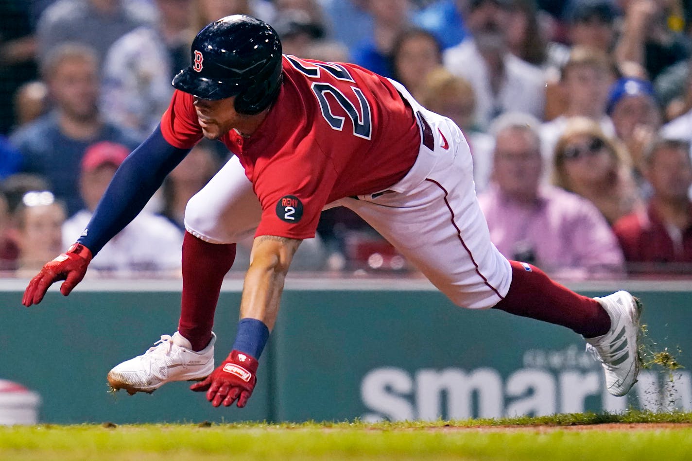 Boston Red Sox's Tommy Pham dives home to score on a double by Rafael Devers during the third inning of a baseball game against the Toronto Blue Jays, Thursday, Aug. 25, 2022, in Boston. (AP Photo/Charles Krupa)