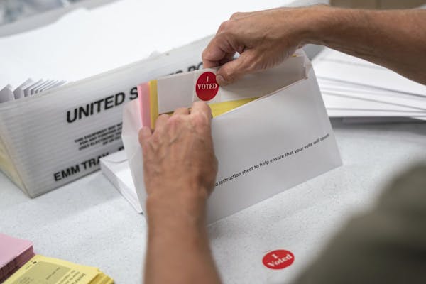 Todd Gallagher prepared mail-in ballot envelopes including an "I voted" sticker in Minneapolis in July.