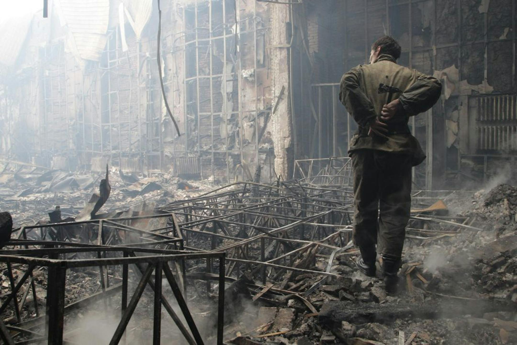 DONETSK, UKRAINE - AUGUST 28: An Ukrainian walks among the ruin of Youth Culture Center building that hit by pro Russian separatists and burn up after shelling, in Donetsk, Ukraine on 28 August, 2014.