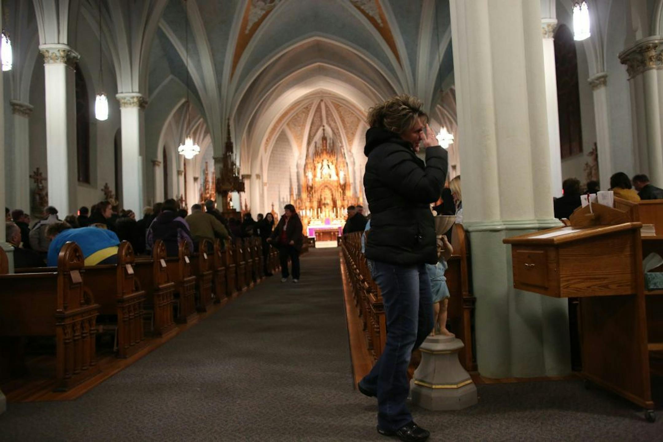 A community membertook some holy water after the prayer service for the four boys killed in a car accident.