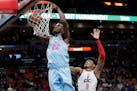 Miami Heat forward Jimmy Butler (22) dunks over Washington Wizards forward Rui Hachimura (8) during the second half of an NBA basketball game, Friday,