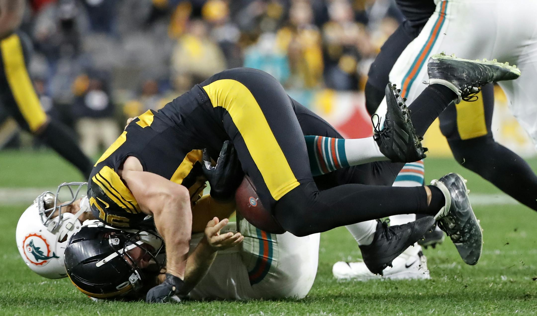 Pittsburgh Steelers outside linebacker T.J. Watt, top, sacks and strips the ball from Miami Dolphins quarterback Ryan Fitzpatrick (14) during the second half of an NFL football game in Pittsburgh, Monday, Oct. 28, 2019. Watt recovered the ball for the Steelers. (AP Photo/Don Wright)