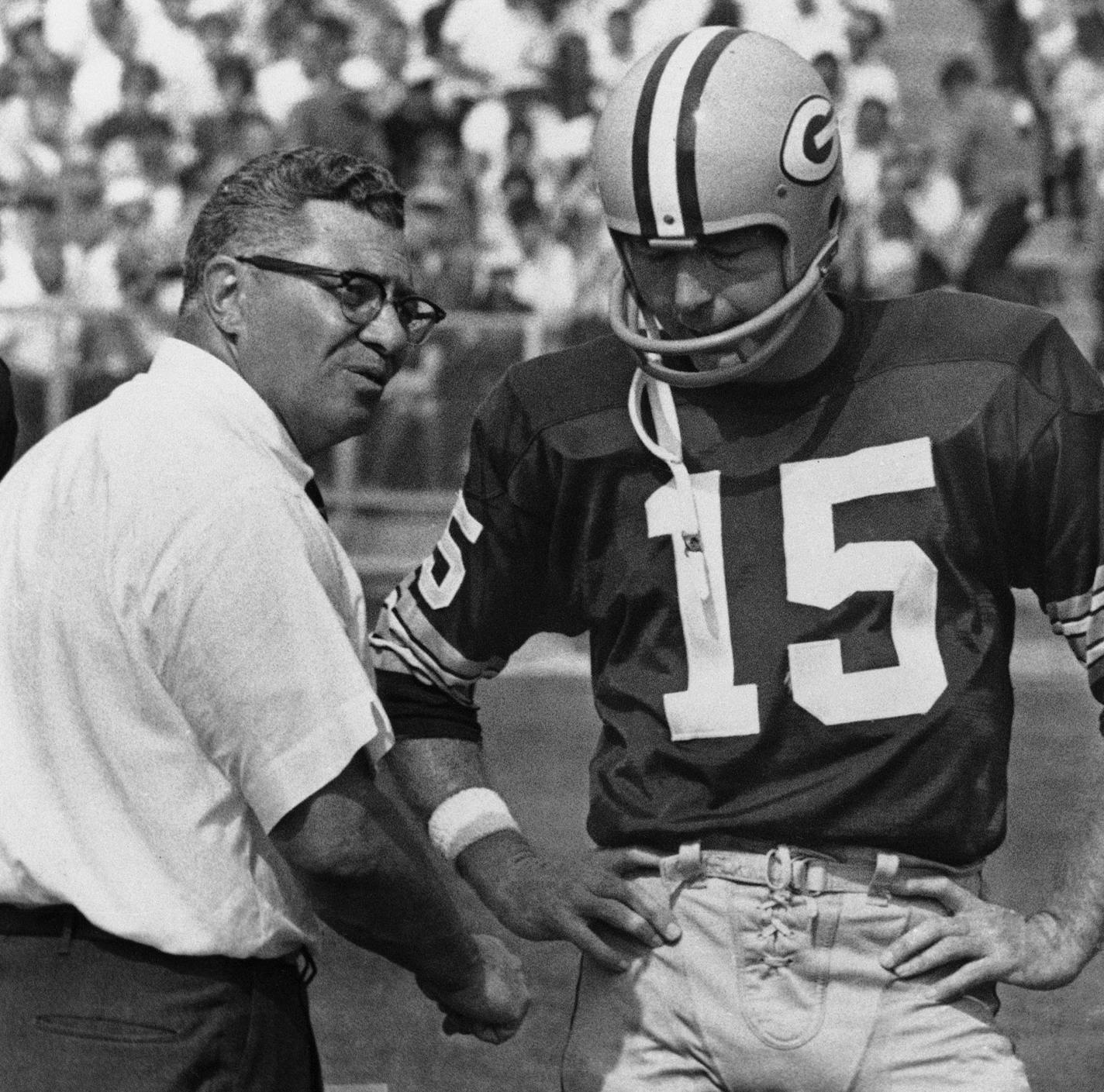 Green Bay Packer coach Vince Lombardi, center, speaks with quarterback Bart Starr (15) and Zeke Bratkowski, left, as the Packers trailed the Detroit Lions at Green Bay, Sept. 18, 1967. The Lions led most of the game, but the Packers managed to catch up in fourth quarter and the contest ended in a 17-17 tie. (AP Photo) ORG XMIT: APHS246992