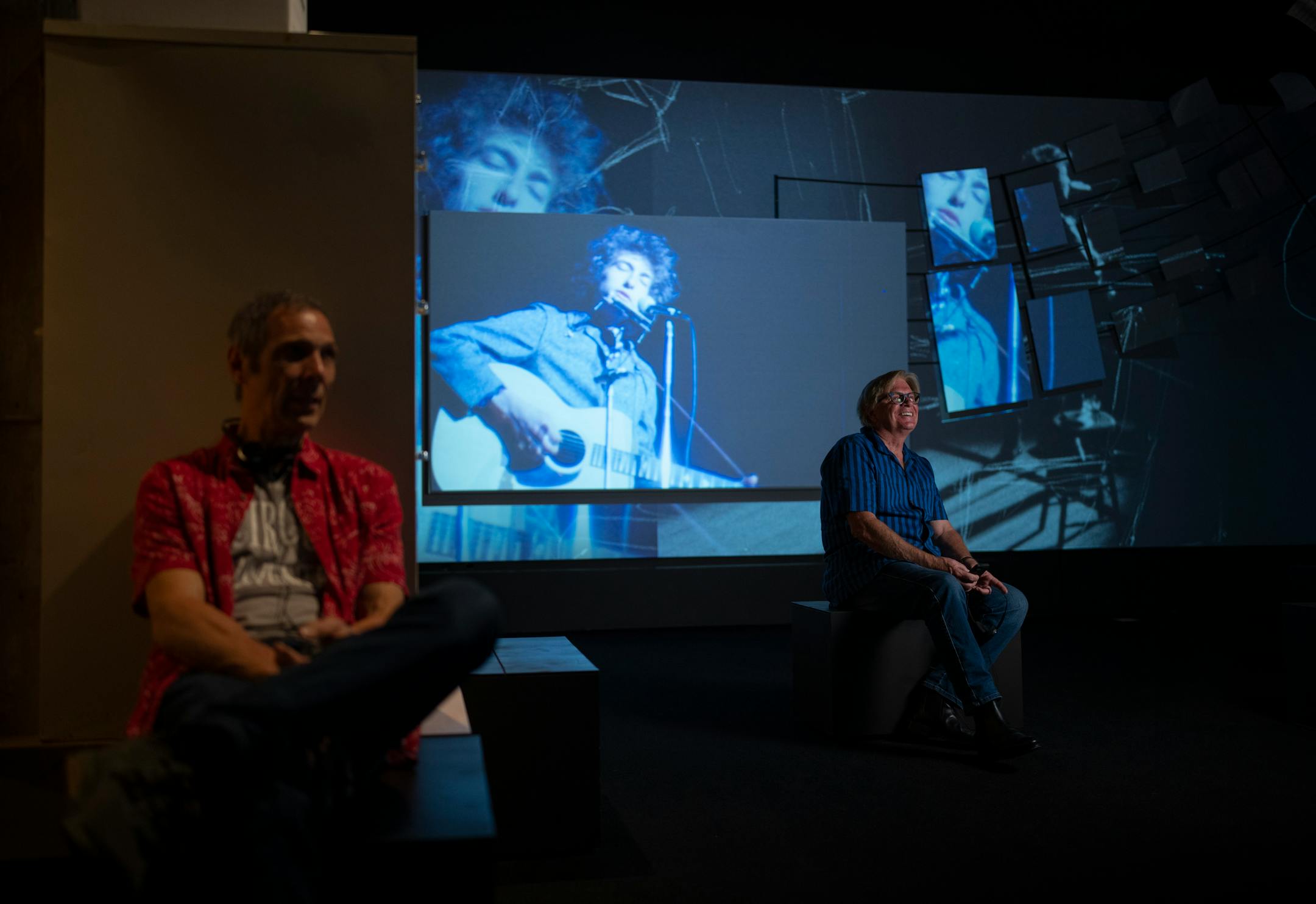 Musicians Gary Lopac, left, and Kevin Odegard watched a multimedia presentation on Bob Dylan on May 7 at the Bob Dylan Center in Tulsa.