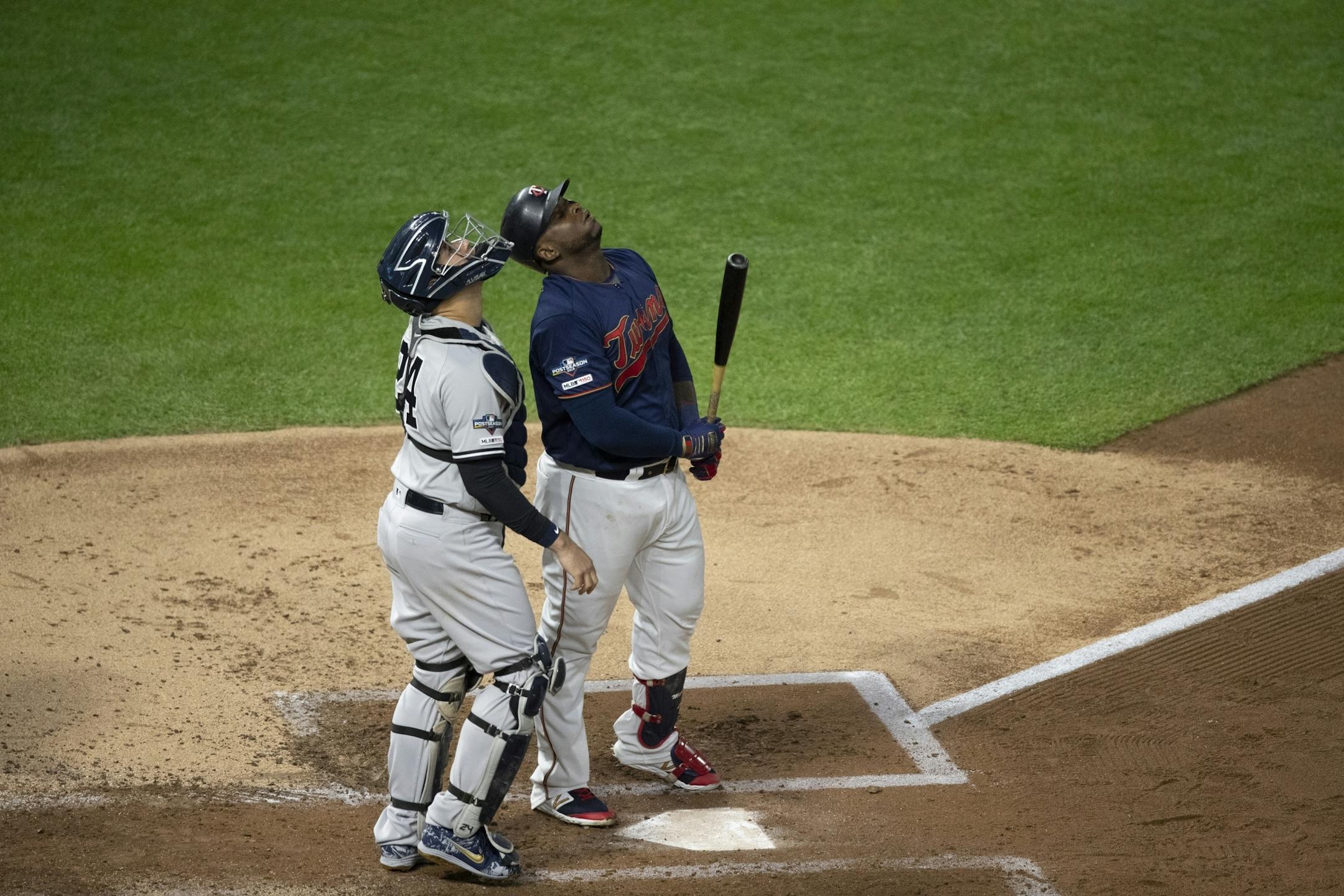 New York Yankees catcher Gary Sanchez (24) and Minnesota Twins third baseman Miguel Sano (22) looked up at an infield fly ball out with bases loaded in the second inning during the third game of the ALDS playoffs at Target Field .