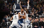 Timberwolves center Rudy Gobert is defended by Grizzlies guard Jordan Goodwin (4) and forward Jaren Jackson Jr. during the first half of the Wolves' 1