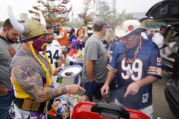 Minnesota Vikings superfan Syd Davy of Vancouver, British Columbia talked with Bears Rick Webber of Plainfield, Ill. as he grilled while tailgating at