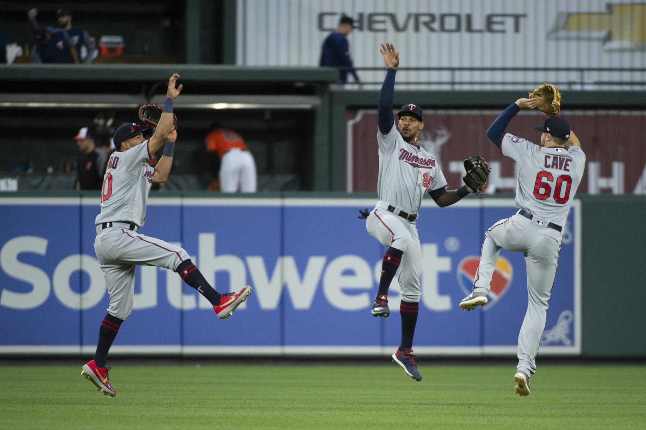 Minnesota Twins left fielder Eddie Rosario, center fielder Byron Buxton (25) and right fielder Jake Cave (60) celebrate on the field after the ninth inning of a baseball game against the Baltimore Orioles, Saturday, April 20, 2019, in Baltimore.