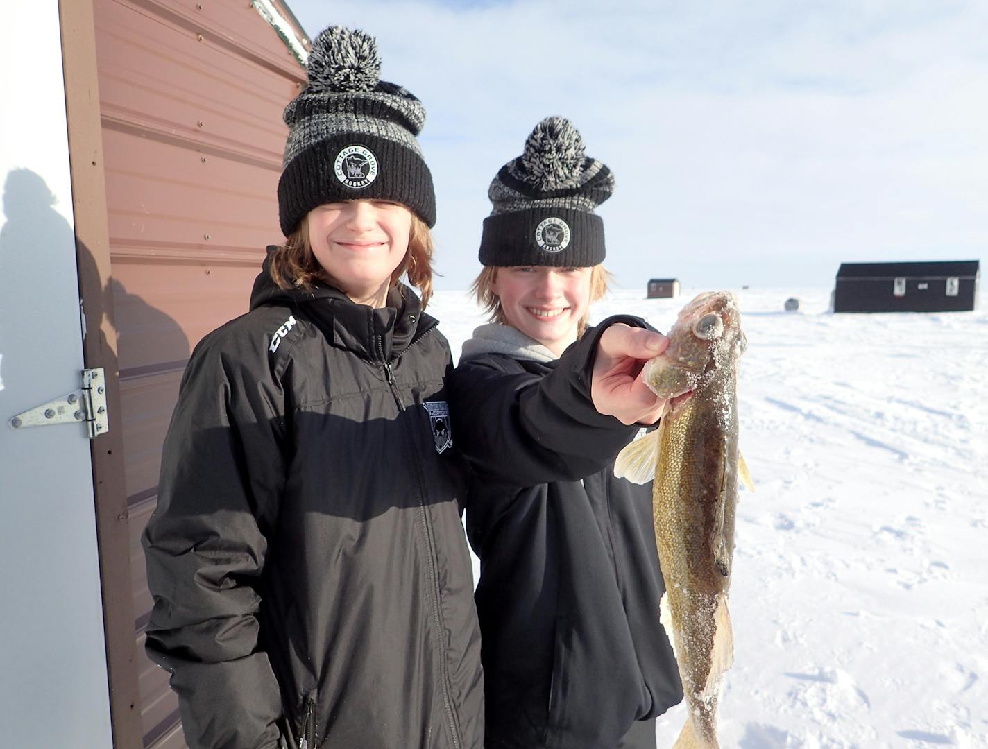 Logan Bachand of Cottage Grove shows off a walleye he caught on Lake of the Woods last week while visiting Warroad for a peewee hockey tournament. All but one of his teammates busted away from the tourney to squeeze in an ice-fishing experience, two miles off shore. Goalie Collin Kabacinski looks on.