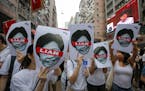 Protesters hold pictures of Hong Kong Chief Executive Carrie Lam as protesters march along a downtown street against the proposed amendments to an ext