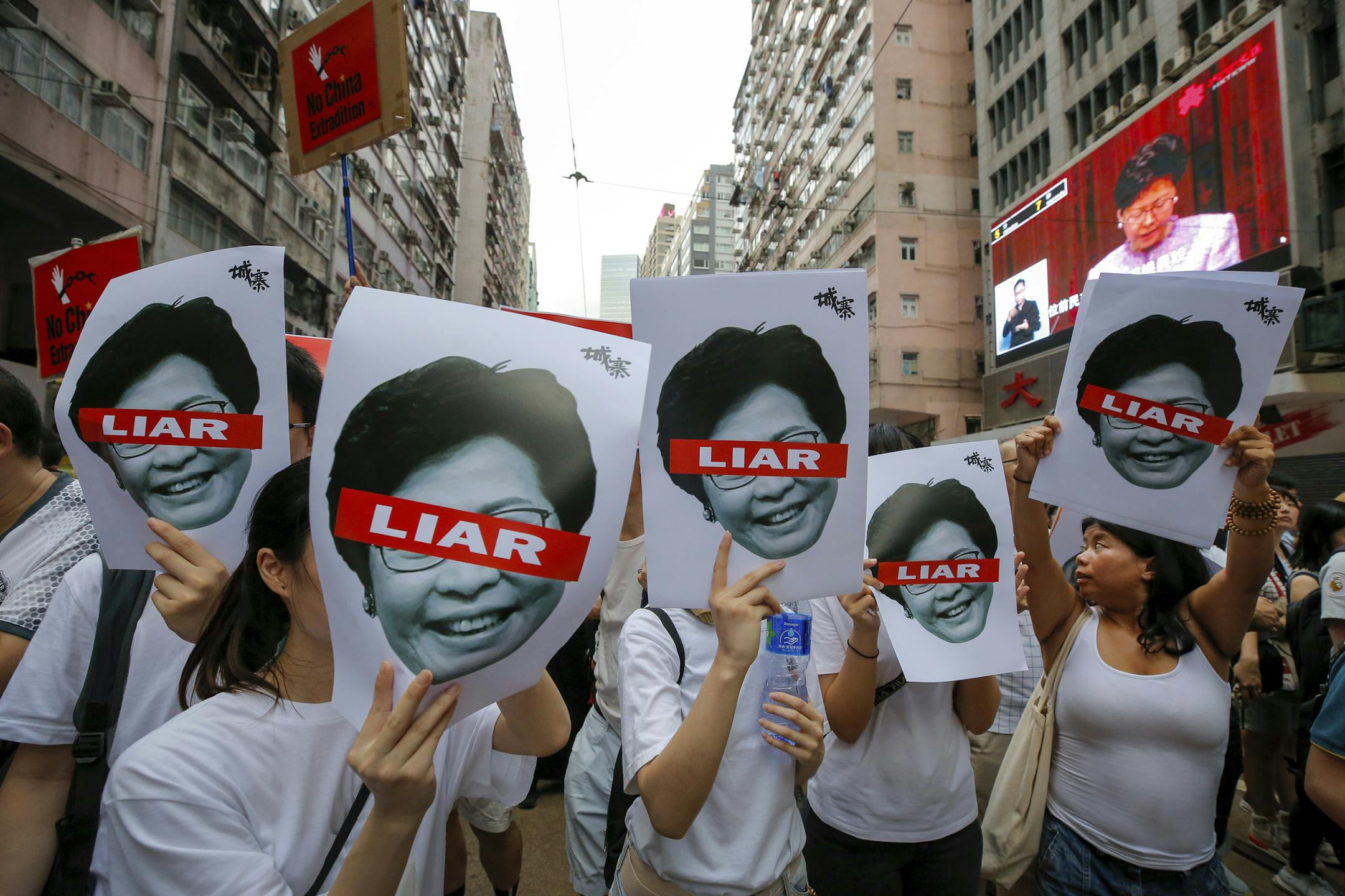 Protesters hold pictures of Hong Kong Chief Executive Carrie Lam as protesters march along a downtown street against the proposed amendments to an extradition law in Hong Kong Sunday, June 9, 2019. A sea of protesters is marching through central Hong Kong in a major demonstration against government-sponsored legislation that would allow people to be extradited to mainland China to face charges. (AP Photo/Kin Cheung)