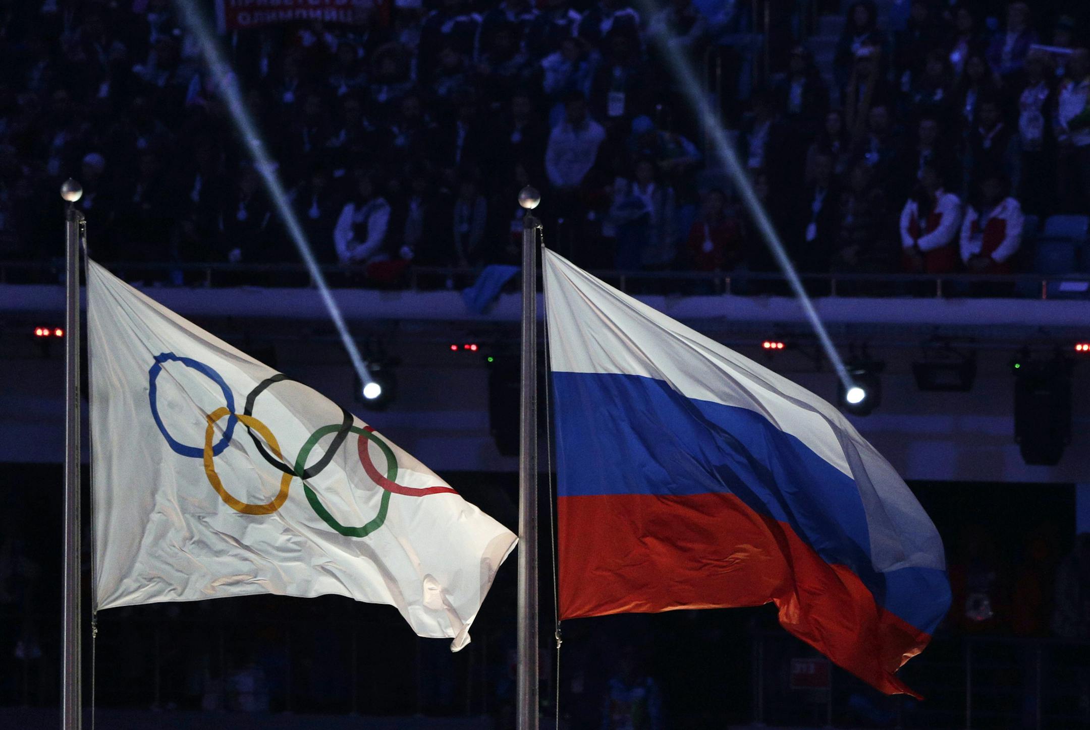 In this Feb. 23, 2014 file photo, the Russian national flag, right, flies after next to the Olympic flag during the closing ceremony of the 2014 Winter Olympics in Sochi, Russia. Russia has been banned from competing at the Pyeongchang Olympics. The decision came Tuesday, Dec. 5, 2017 when the International Olympic Committee executive board met in Lausanne, less than nine weeks before the games open on Feb. 9 in South Korea.