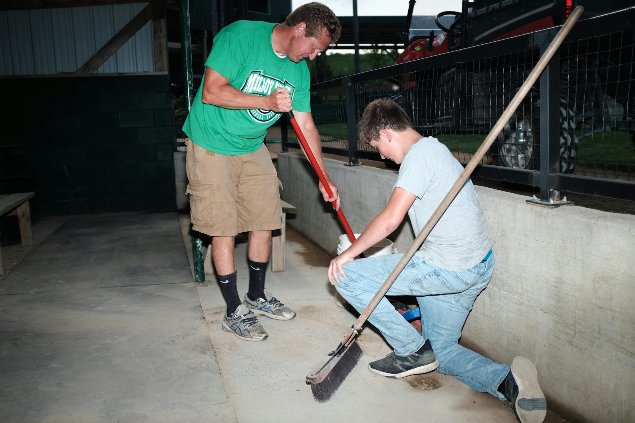 Milroy Irish manager Bob Dolan and his 14-year-old nephew Ezekiel Dolan clean the dugout at Irish Yard.