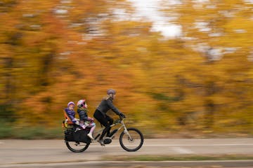 Aimee Witteman on her commuting route home on West River Parkway with her daughters Barrett, 3, and Georgia, 6, on board her cargo bike in October 201