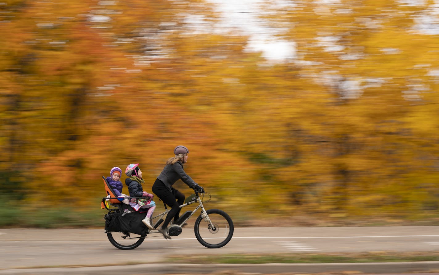 Aimee Witteman on her commuting route home on West River Parkway with her daughters Barrett, 3, and Georgia, 6, on board her cargo bike in October 2019.