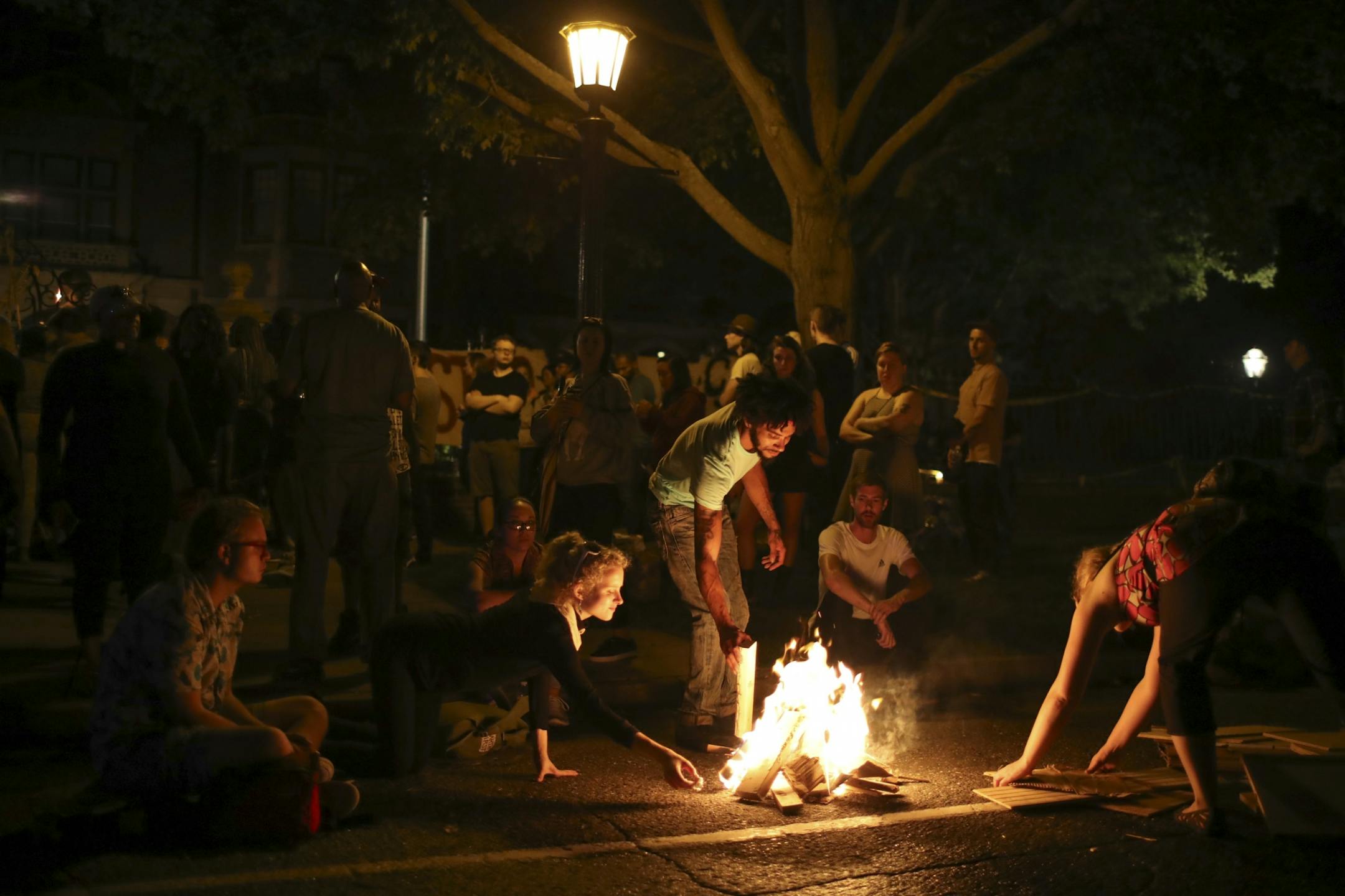 Demonstrators in front of the Governor's Residence in St. Paul tended to a small fire in the street early Thursday morning, July 7, 2016.