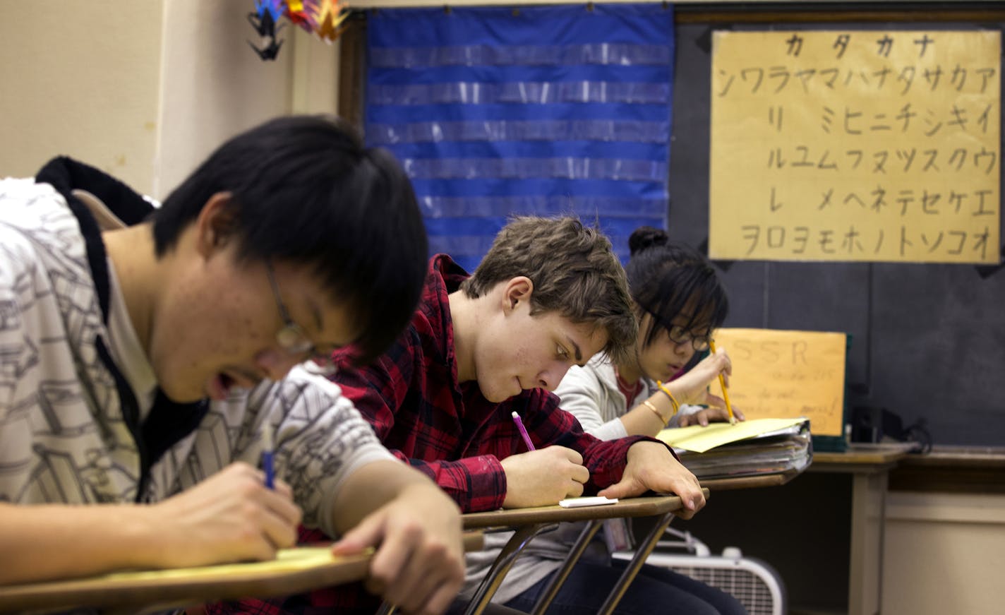 Sophomore Xavier Mansfield, center, 16, works on writing skills during Japanese III class at Patrick Henry High School in Minneapolis on Friday, December 5, 2014. ] LEILA NAVIDI leila.navidi@startribune.com /