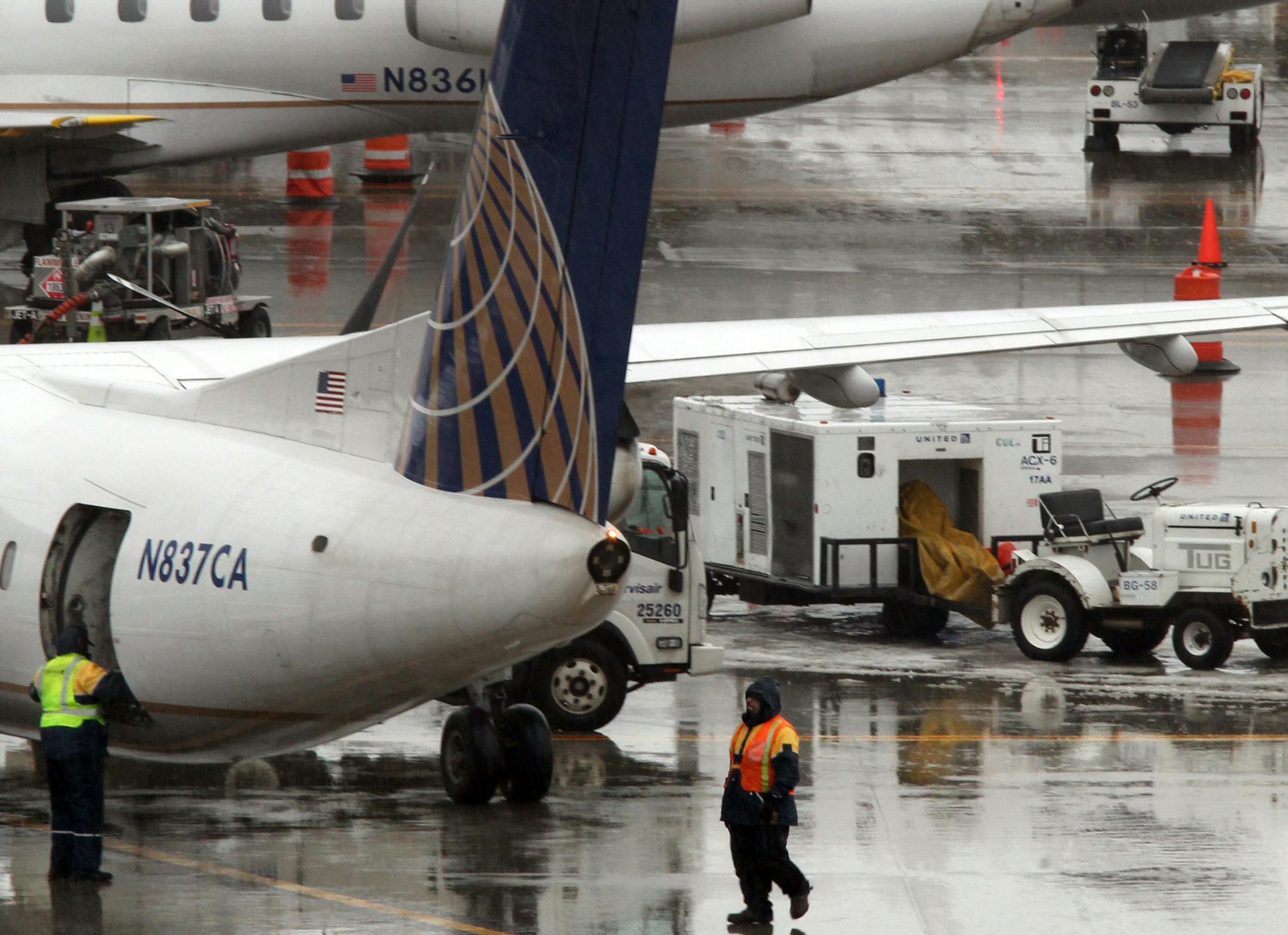 In this Feb. 1, 2014 photo, United Airlines baggage handlers prepare to unload a commuter flight that landed at Cleveland Hopkins International Airport.