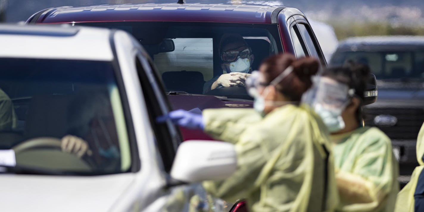 Riverside County medical personnel administer coronavirus tests at a drive-though testing facility at Diamond Stadium on March 21, 2020 in Lake Elsinore, Calif. Those tested have symptoms or have had a risk of exposure. (Gina Ferazzi/Los Angeles Times/TNS) ORG XMIT: 1636175