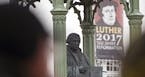 Visitors walk in front of the Martin Luther monument prior the celebrations on the occasion the 500th Anniversary of the Reformation in Wittenberg, Ge