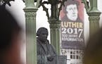 Visitors walk in front of the Martin Luther monument prior the celebrations on the occasion the 500th Anniversary of the Reformation in Wittenberg, Ge