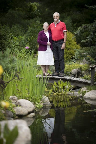 Karen and Emery Koenig stand on the footbridge in the garden they created in Waconia.